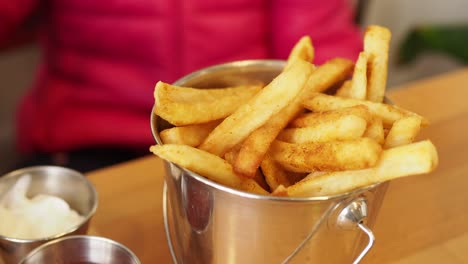 el niño recoge a mano las papas fritas en la mesa,