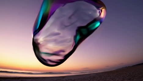 iridescent fluid shape floating over a sunset beach