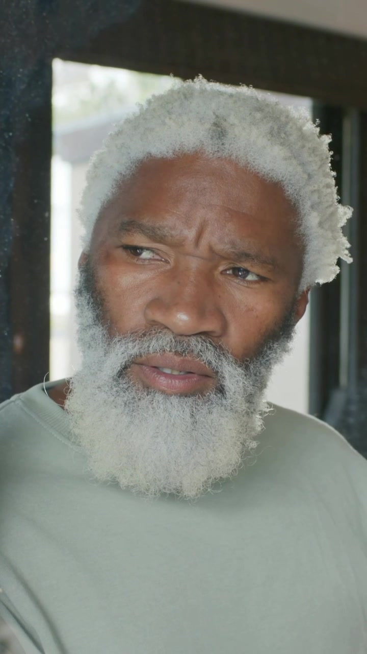 Vertical video: Lifting head, senior man with white beard shifting gaze at home by window, thinking