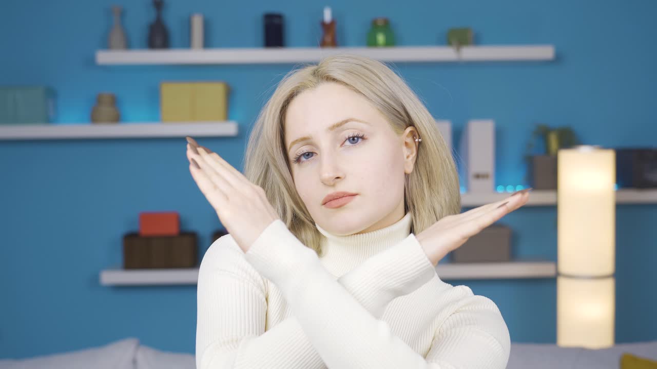 받아들이지 않는 젊은 여자는 "아니오"라고 말하고, 손으로 "아니오"라는 표시를 합니다.