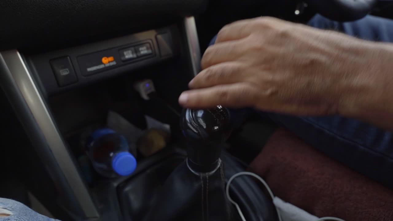 Close-up of male hand changing gear while driving an electric car
