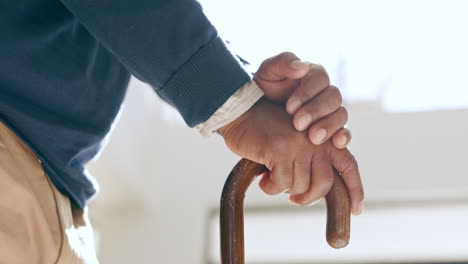 cane, hands and elderly man in home living room