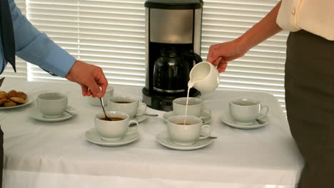 gente de negocios haciendo café en la sala del personal.