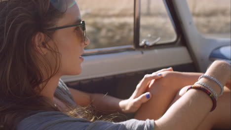 beautiful girl on adventure road trip in vintage convertible enjoying the wind in her hair