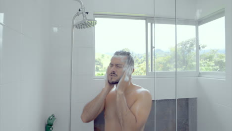 man in the shower puting shampoo on his hair on a beautiful bathroom