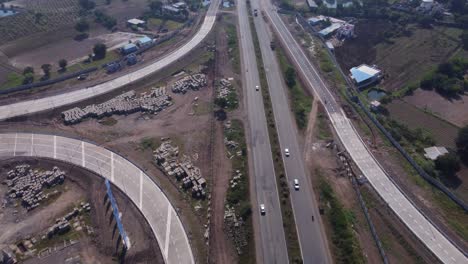 Drone-view-of-travelling-on-Pune-Nashik-highway-at-the-Interchange-of-Samruddhi-Mahamarg-also-known-as-Nagpur-to-Mumbai-Super-Communication-Expressway,-an-under-construction-6-lane-highway