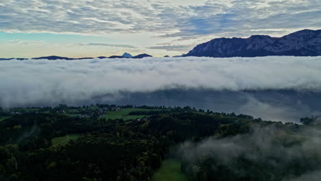 Inversión-Masiva-De-Nubes-Sobre-El-Campo-Alpino,-Picos-De-Montañas-Arriba