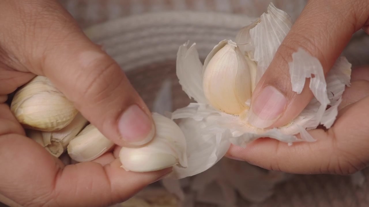 Close-up Tangan Mengupas Bawang Putih Segar