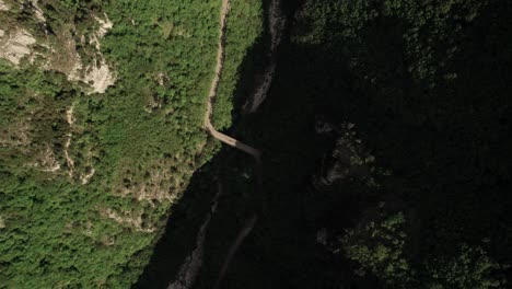 Aerial-tilt-down-view-of-a-green-valley-into-the-mountains