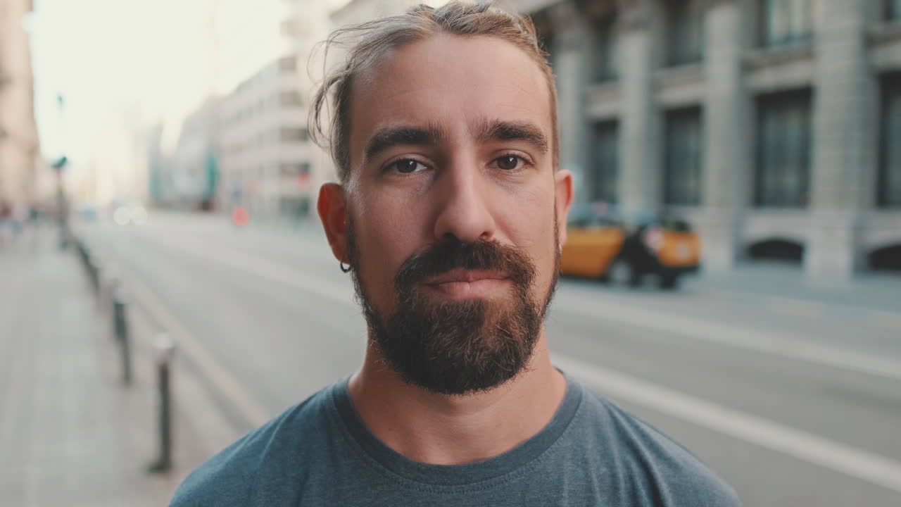 Uomo con la barba che sorride in strada