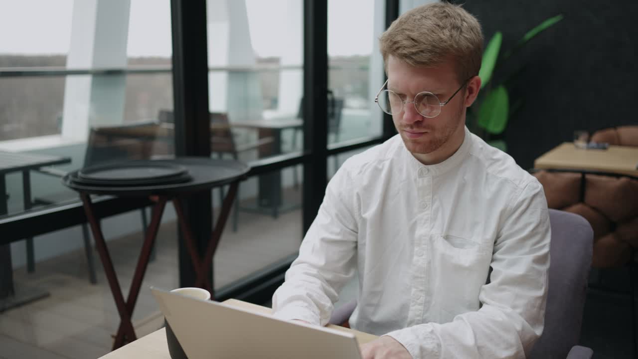 трейдер-фрилансер работает в кафе или в коворкинге, использует интернет или wi-fi на ноутбуке, просматривает веб-страницы