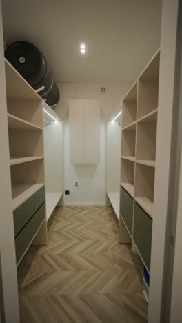 large spacious empty walk-in closet with white cabinets, drawers, and holders for hangers. beautiful wardrobe for placing clothes and shoes. interior design concept