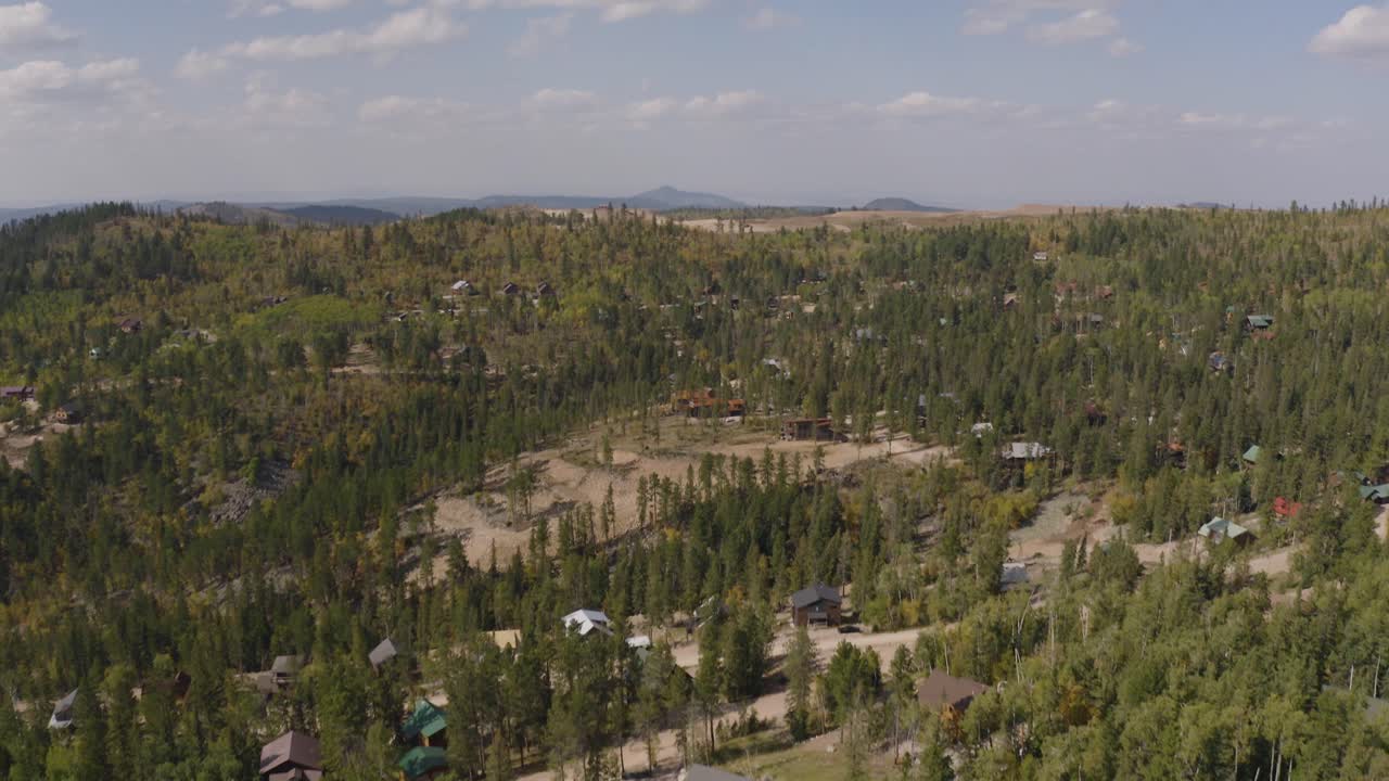 Ripresa con drone di case e area boschiva nel Dakota del Sud, intorno a Lead e Terry Peak. Avanzamento e inclinazione verso l'alto.