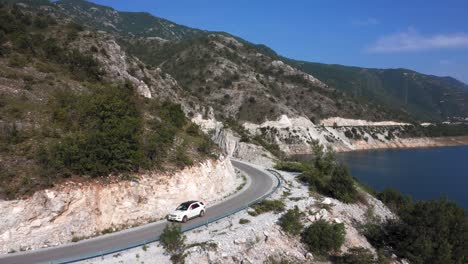 car driving on the peaceful roads at kozjak lake on a beautiful sunny day with blue skies