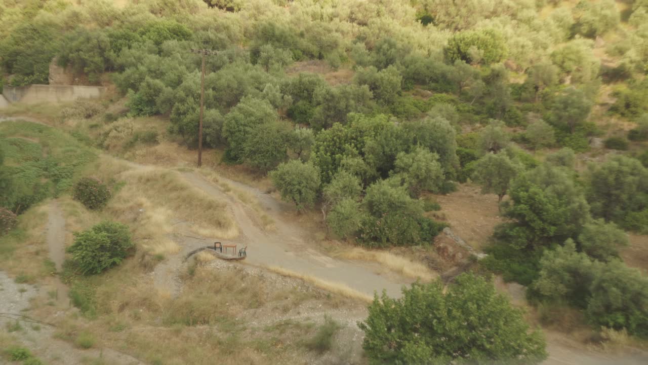 paisaje mediterráneo árido con hierba de arbusto verde y camino de tierra sinuoso