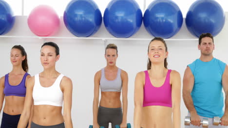 aerobics class lifting dumbbells together