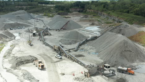 daylight aerial wide shot of active limestone quarry with trucks and conveyors