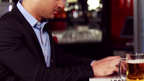 businessman having a drink while working on his laptop