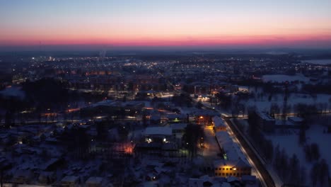 Flug-über-Eine-Stadt,-Die-Von-Einem-Fackelschein-Bei-Sonnenuntergang-Beleuchtet-Wird