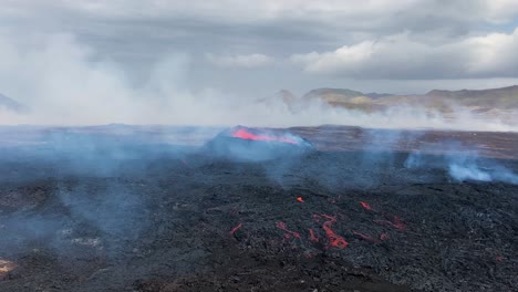 erupciones volcánicas de lava roja que sale de un lecho de lava negra oscura