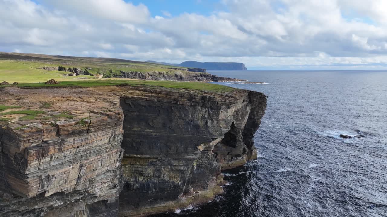 vista aérea de la pintoresca costa de escocia, reino unido, acantilados, cuevas y pastos verdes sobre las olas del mar
