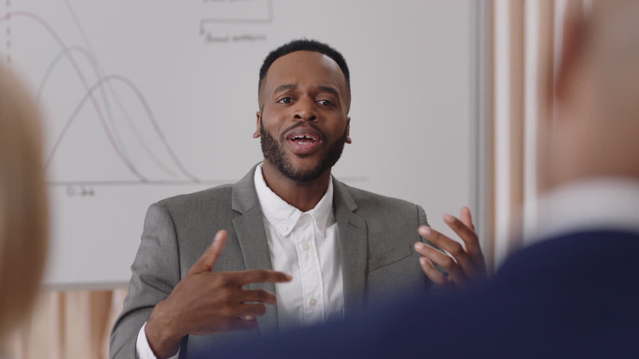 african american businessman team leader meeting with colleagues sharing creative ideas for startup project discussing corporate strategy in office boardroom