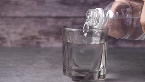 pouring water from a plastic bottle into a glass