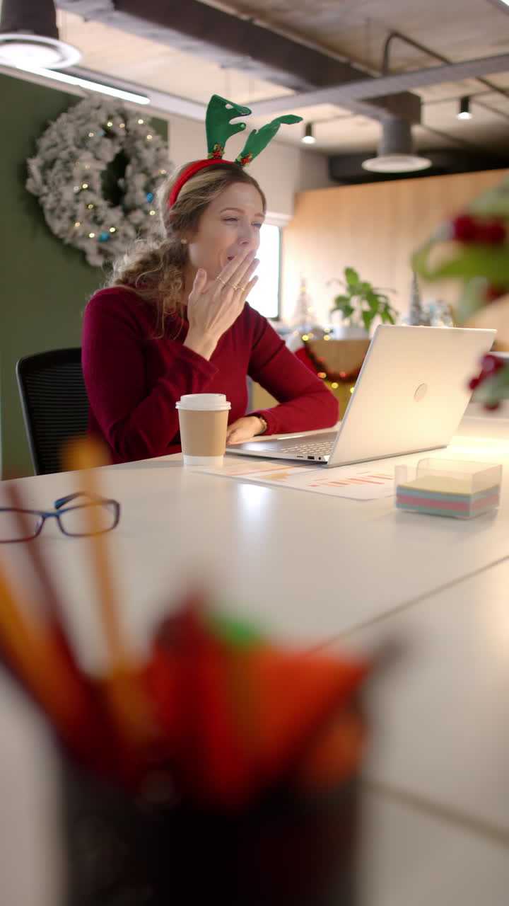 Vertikal video af glad kaukasisk afslappet forretningskvinde, der foretager videoopkald på kontor, i slowmotion.