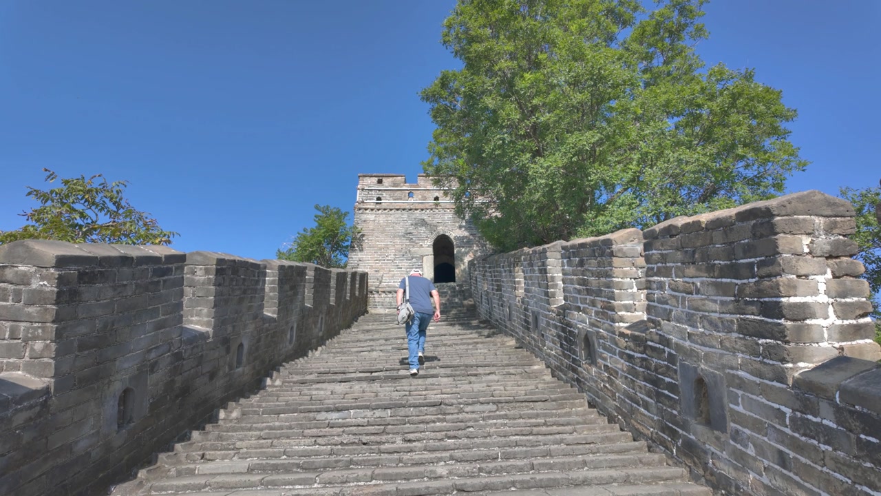 4K video of an old man walking up the steps on the great wall of China