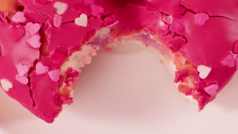 pink heart donut with a bite taken out