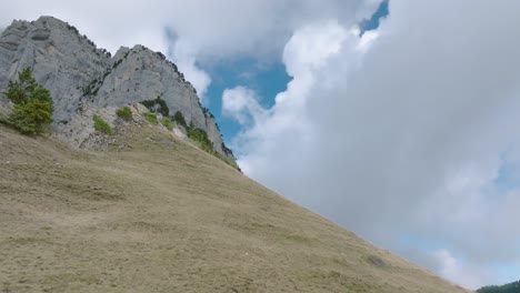 Tiro-De-ángulo-Bajo-Subiendo-Una-Colina-Con-Hermosas-Nubes,-Alpes-Franceses