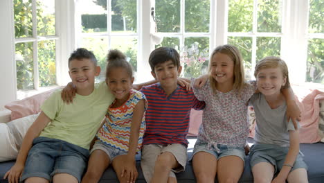 grupo de niños multiculturales en el asiento de la ventana juntos