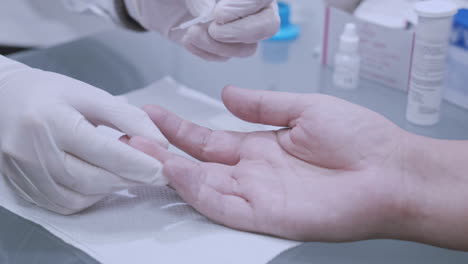 finger blood test. doctor doing blood analysis. doctor hands using lancelet