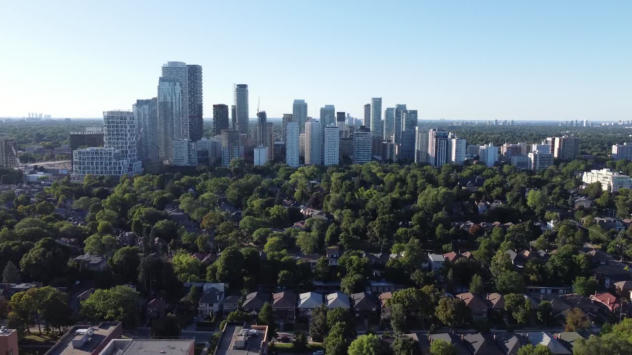 Aerial shot flying towards large buildings in a Toronto neighborhood