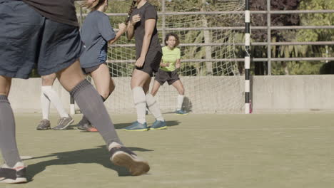 cámara lenta de una jugadora de fútbol irreconocible tomando un tiro libre mientras el equipo oponente defiende el gol con éxito y celebra