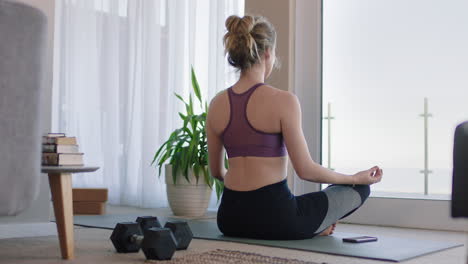 healthy yoga woman practicing meditation in living room enjoying morning mindfulness exercise at home