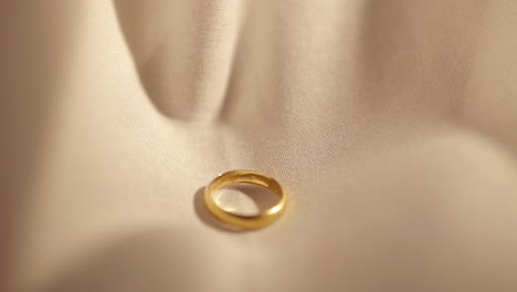 wedding gold rings dropped on white cloth background