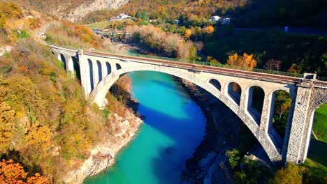 Stunning-aerial-4K-drone-footage-of-Solkan-arch-bridge-over-the-Soča-river,-a-majestic-stone-marvel-located-in-western-Slovenia