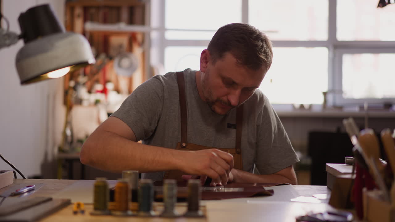 el sastre dibuja marcas en el cuero en el lugar de trabajo en el taller en el hogar