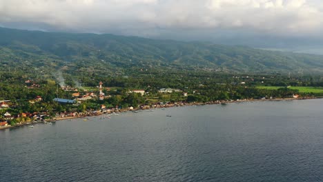 hermosa costa del norte de bali en lovina indonesia con paisaje montañoso y océano azul al atardecer, aéreo