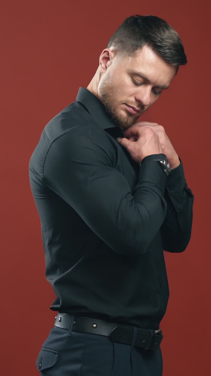 Handsome man with strong body in a dark shirt preparing and having look at the camera. Half waist view video. Vertical video