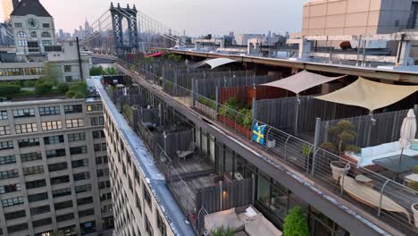 Cinematic-drone-flight-along-luxury-apartment-with-small-terraces-in-Dumbo-District-of-Brooklyn-and-Manhattan-bridge-in-Background---Slow-forward-flight