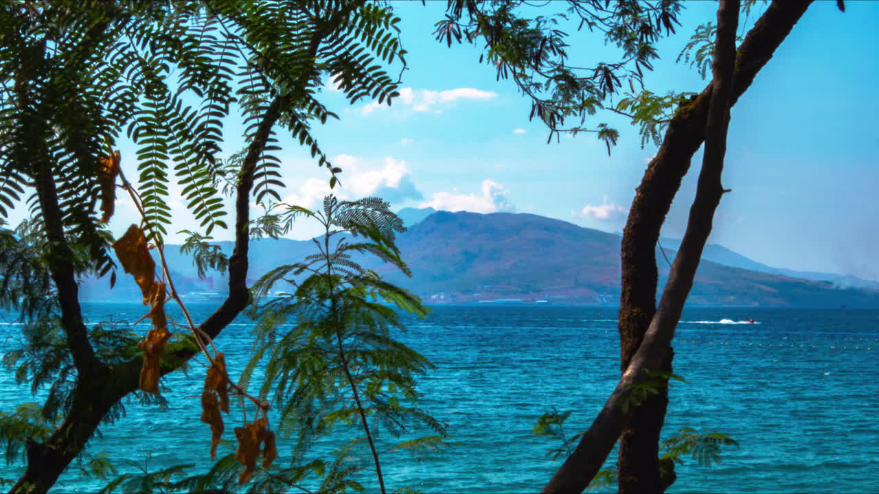 Beautiful Time lapse of Beach with Jet Ski and Ship Passing with Mountains and Clouds In The Background