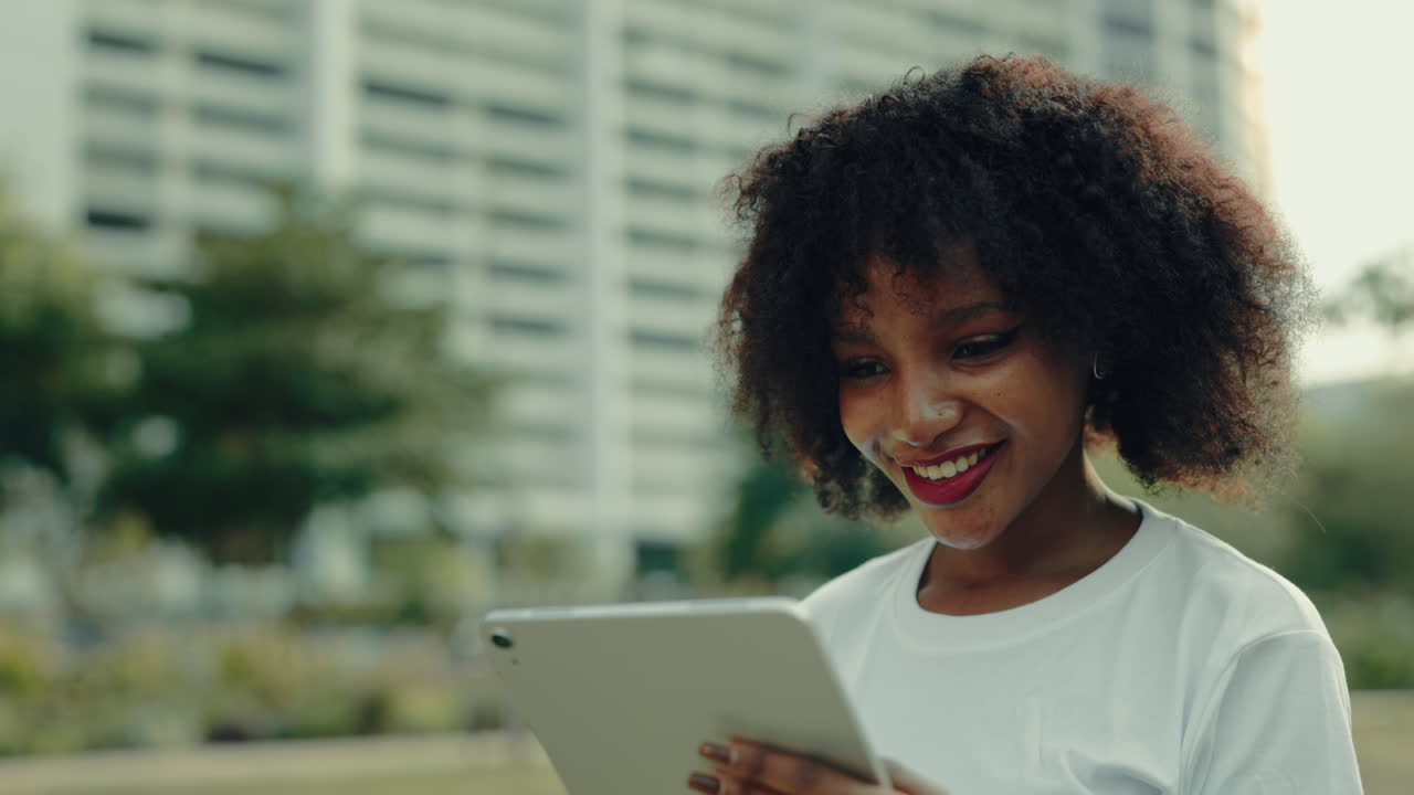 Young Woman Using Tablet in a City Park