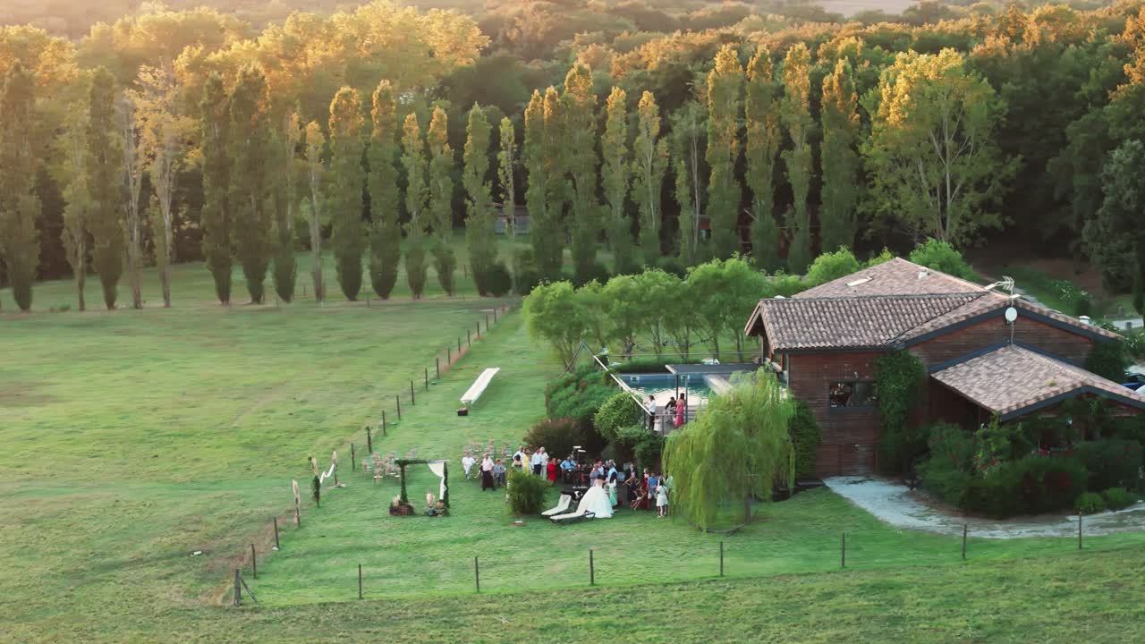 Aerial establishing shot of a small wedding party gathering at a villa in France