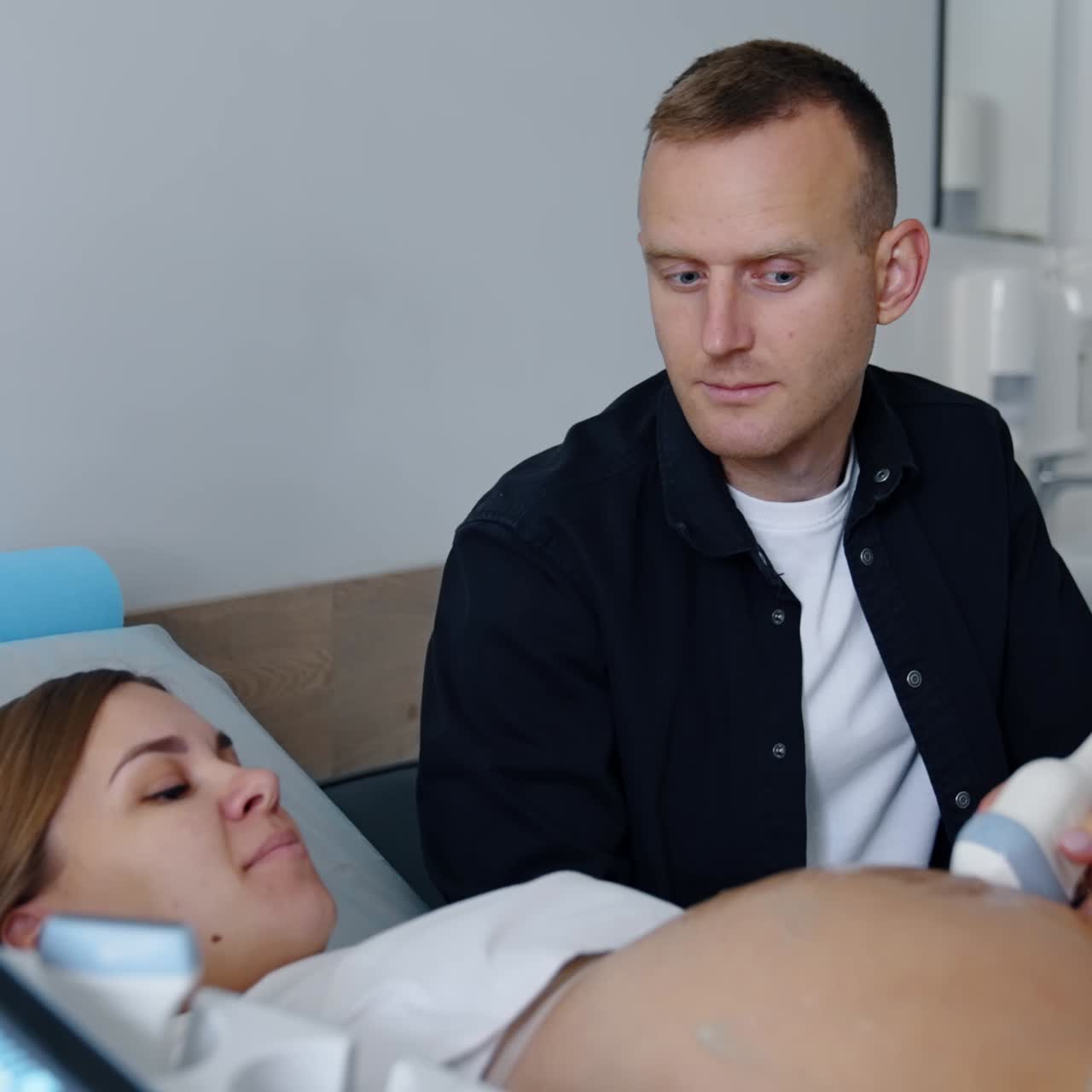 Man and woman are at the doctor's cabinet. Couple is having the pregnancy diagnostics