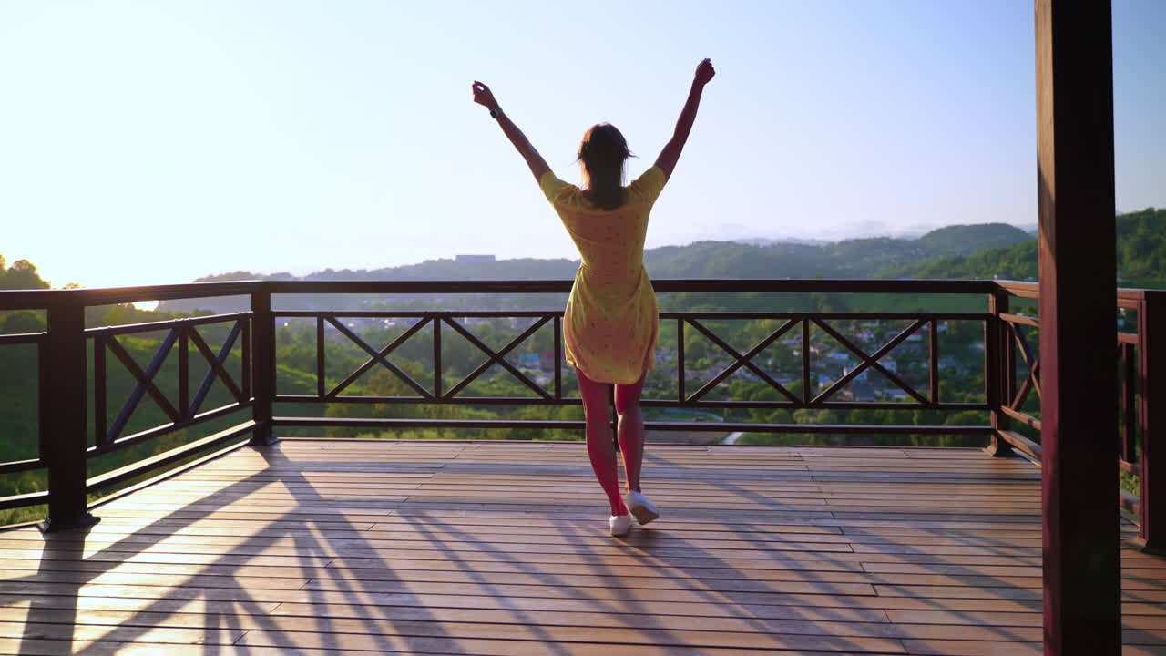 mujer disfrutando de una hermosa vista desde un balcón al amanecer o al atardecer.