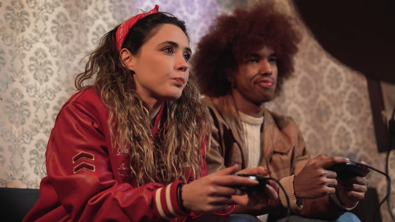 pareja diversa con ropa retro jugando a videojuegos usando joysticks