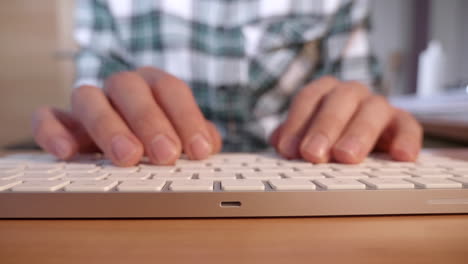 a close up shot of a man typing on an apple mac keyboard