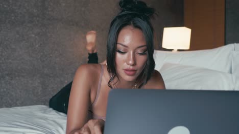 mujer trabajando en la computadora portátil en la cama